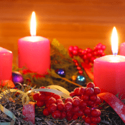 Christmas display with four red candles and baubles.