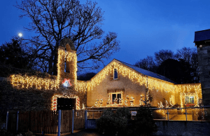 Image of festive Christmas lights festooning the entrance to the Walled Garden for Glow in the Garden 2025.